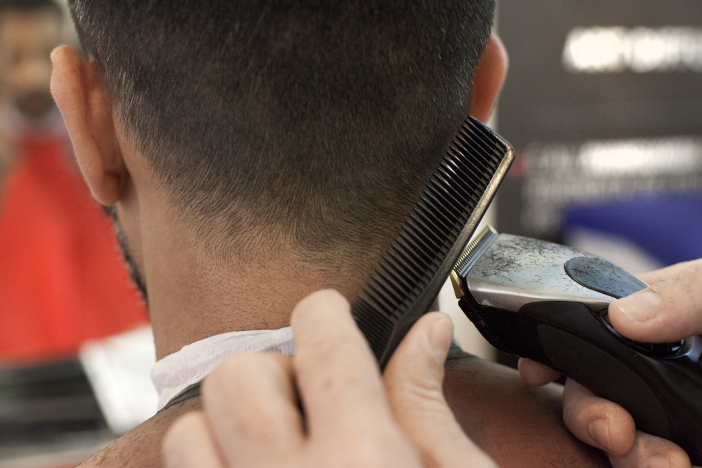 Un parrucchiere mentre taglia i capelli